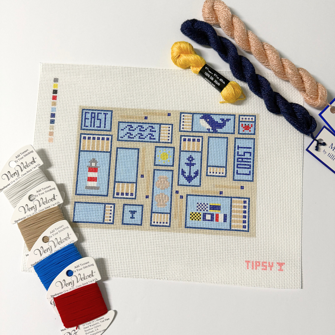 needle point kit with pre-printed pattern on fabric, yarn skeins, and color swatches.