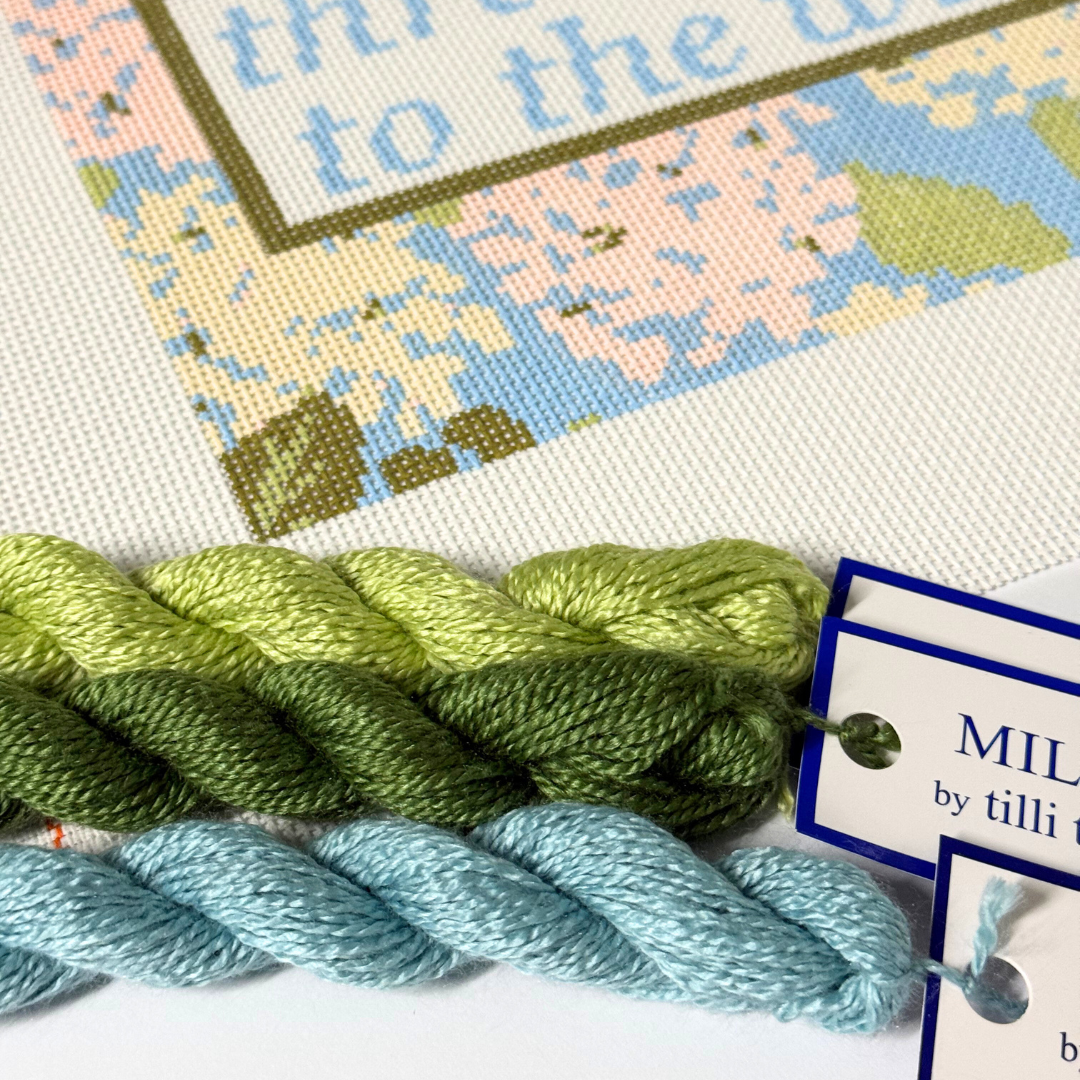 Needlepoint Kit with green and blue yarn, featuring a label for &
