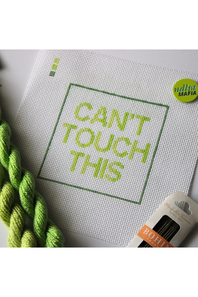 Threaded & Tipsy hand-painted needlepoint canvas featuring the phrase “CAN’T TOUCH THIS” in bold gradient lime and yellow-green block letters, framed by a green rectangular border. A small painted color guide with three green shades appears in the top left corner. Surrounding the canvas are twisted skeins of green needlepoint threads, a pack of Bohin embroidery needles in the bottom right, and a round lime green enamel pin in the top right corner that reads “ndlpt MAFIA.” 