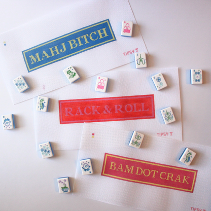 Colorful game pieces with needlepoint canvases featuring humorous text on a white background