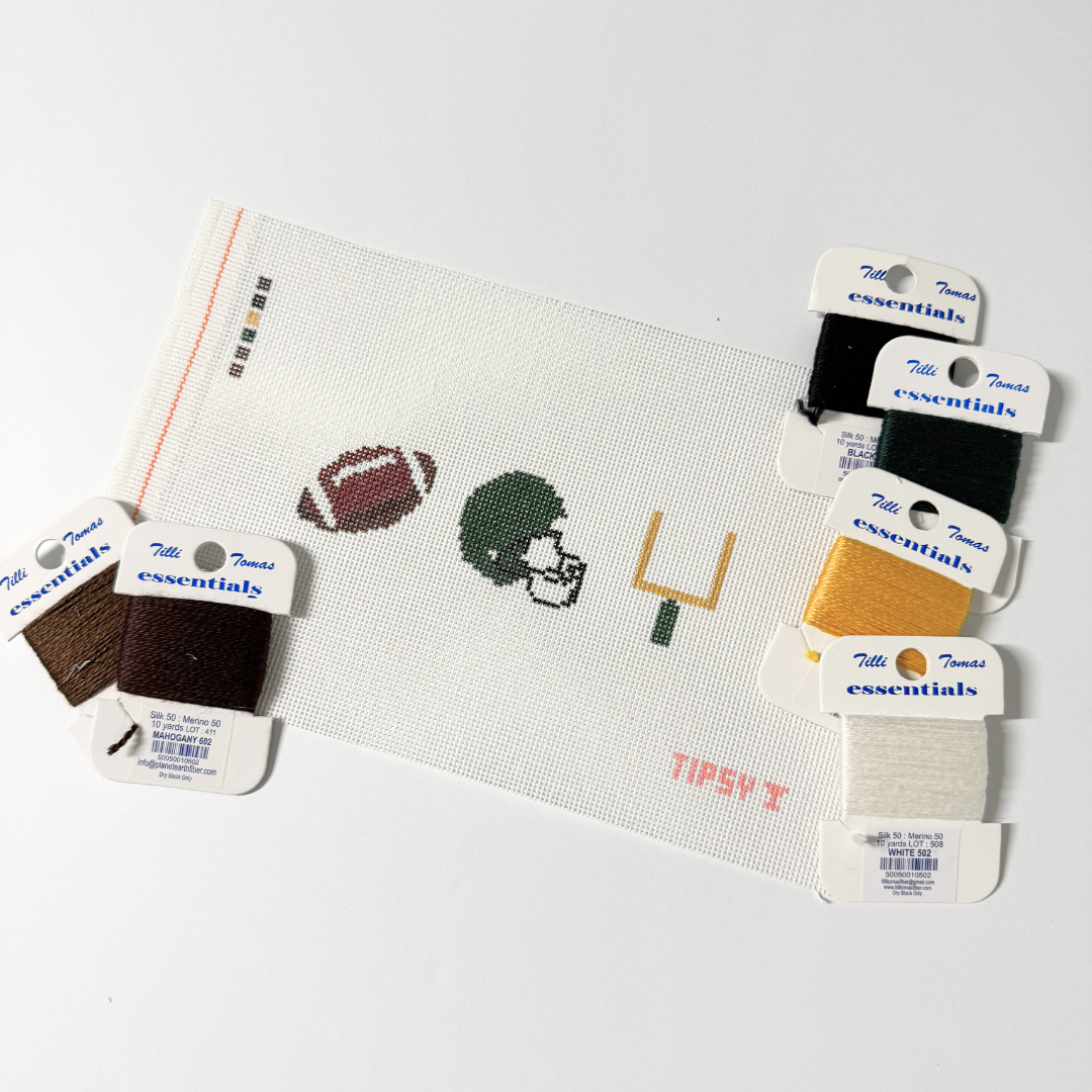 Color swatches and a needlepoint kit on canvas with sports-themed elements.