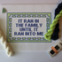 Threaded & Tipsy hand-painted needlepoint canvas featuring the phrase “IT RAN IN THE FAMILY UNTIL IT RAN INTO ME” in bold navy blue block letters. The quote is framed by a navy and lime green geometric border. Surrounding the canvas are twisted skeins of needlepoint threads in cream, lime green, and navy blue, along with a pack of Bohin embroidery needles in the bottom right corner. A small enamel pin shaped like a green Christmas tree is pinned in the upper left corner of the canvas.