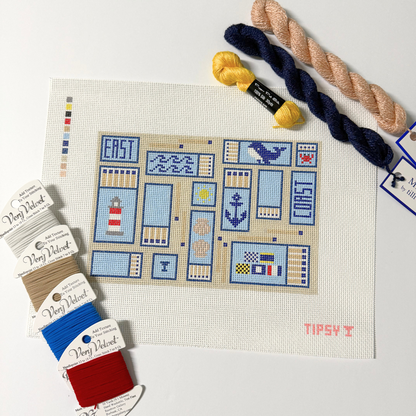 needle point kit with pre-printed pattern on fabric, yarn skeins, and color swatches.
