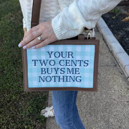 Person holding a self finishing needlepoint bag with text &