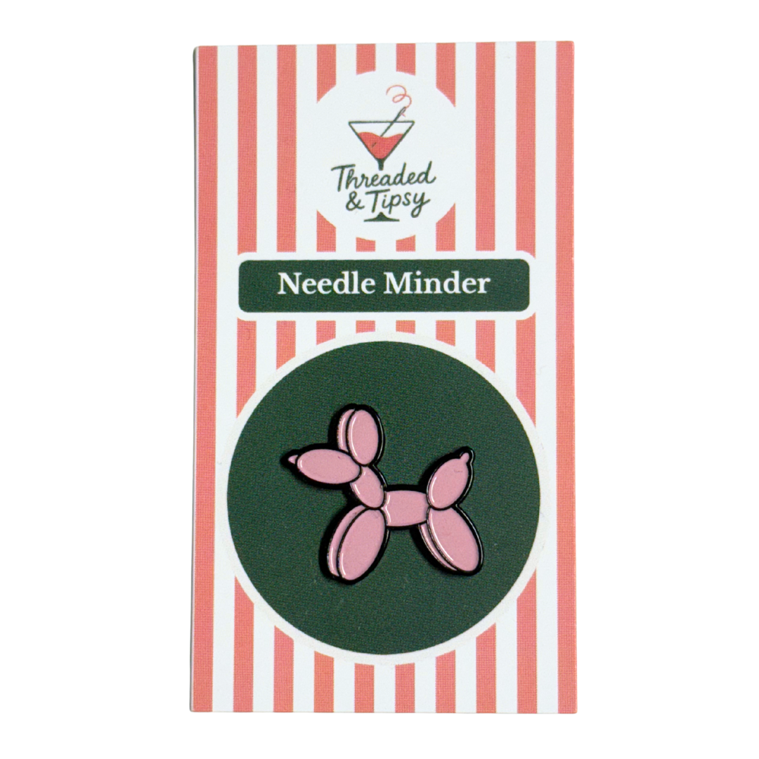 Pink balloon dog needle minder on striped packaging with &