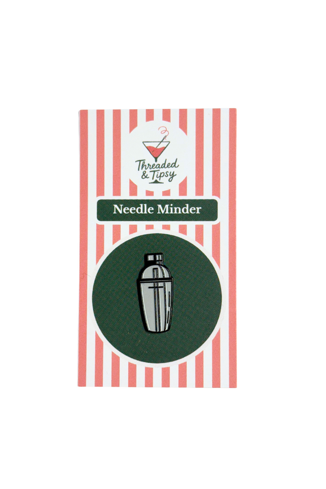 Packaging of a Needle Minder with striped design and brand logo.