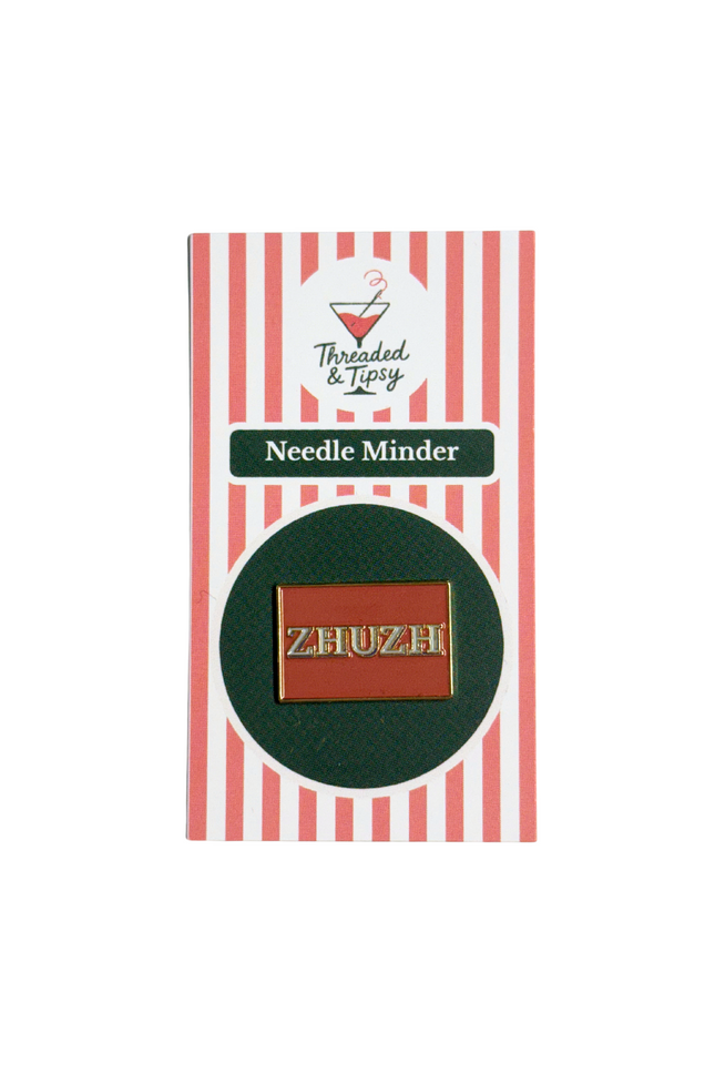Zhuzh needle minder on striped packaging with 'Threaded & Tipsy' branding