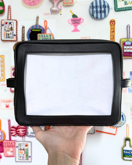 Needlepoint Self-Finishing Black Pouch background with various small objects.