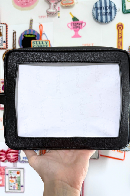 Needlepoint Self-Finishing Black Pouch background with various small objects.