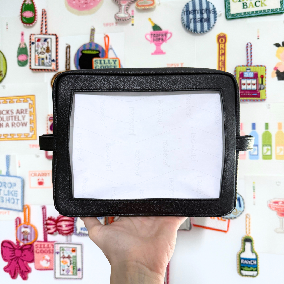 Needlepoint Self-Finishing Black Pouch background with various small objects.