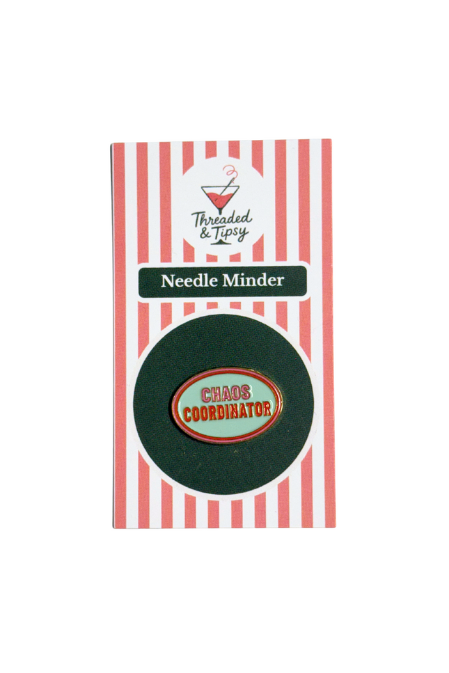 Green needle minder with 'Chaos Coordinator' badge on striped packaging