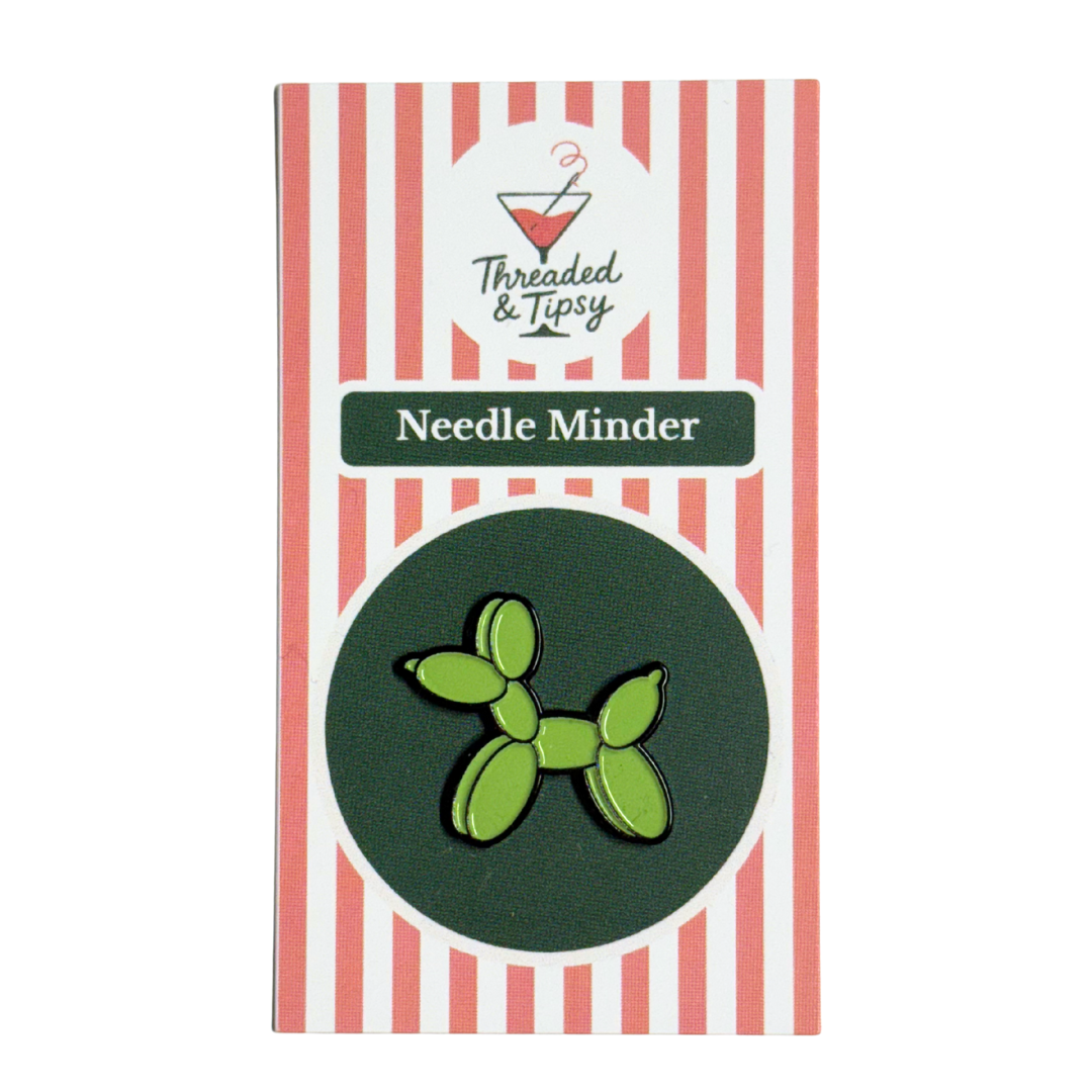 Green balloon dog needle minder on striped packaging with &