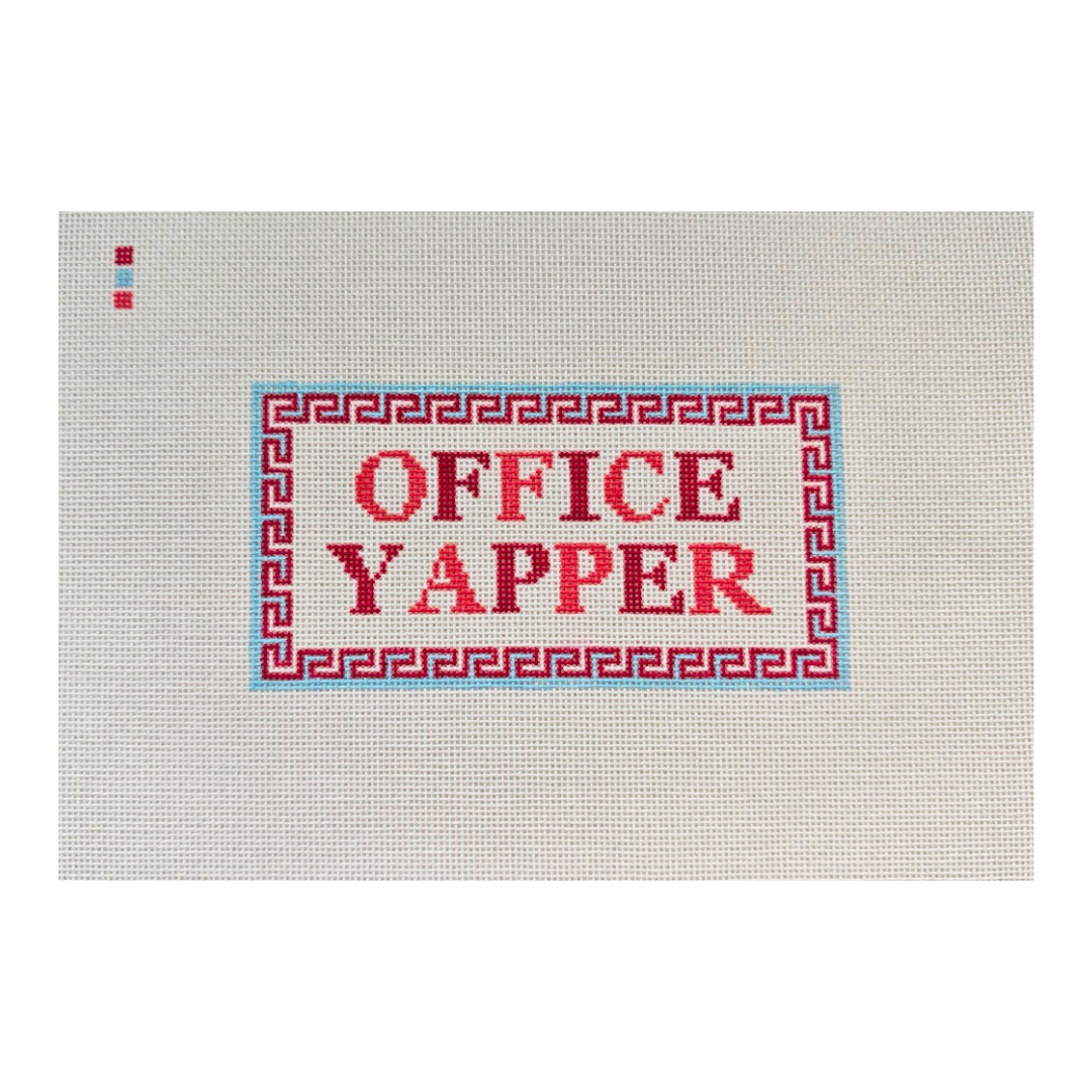 Threaded &amp; Tipsy hand-painted needlepoint canvas featuring the phrase “OFFICE YAPPER” in bold red and burgundy block letters. The text is centered within a red Greek key-style border outlined in light blue. A small painted color guide with three swatches in shades of red is located in the upper left corner. The canvas is unstitched and displayed against a plain white background.