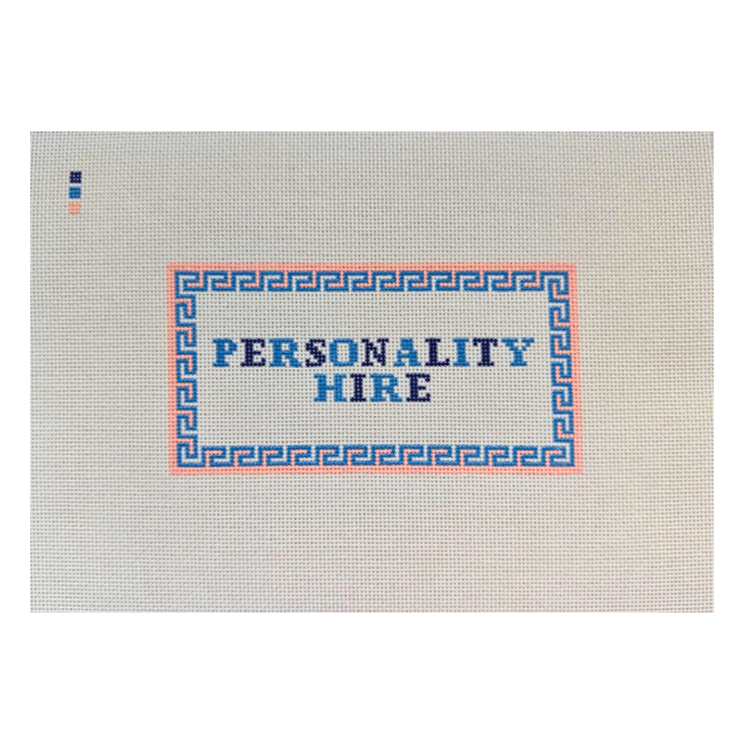 Threaded &amp; Tipsy hand-painted needlepoint canvas featuring the phrase “PERSONALITY HIRE” in bold blue and navy block letters. The text is framed by a pink and blue geometric border. A small painted color guide with three swatches—navy, blue, and peach—is located in the upper left corner. The canvas is unstitched and presented on a plain white background.