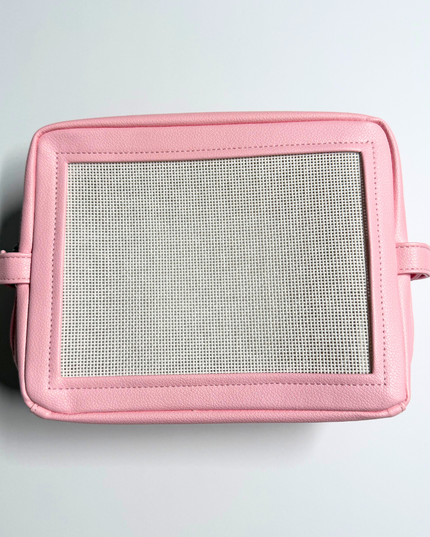 Pink needlepoint stitchable bag with a mesh panel on a light gray background