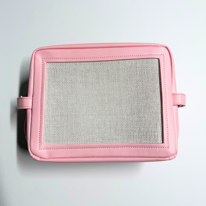 Pink needlepoint stitchable bag with a mesh panel on a light gray background