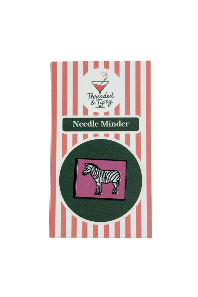 Zebra needle minder on striped packaging with 'Threaded & Tipsy' branding